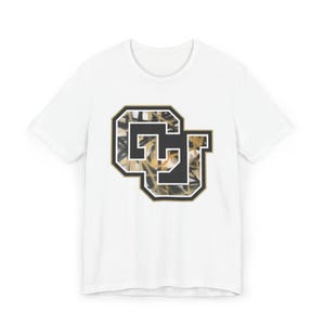 May include: White t-shirt with a black and gold "CU" logo. The logo has a camouflage-style pattern inside the letters and a black and gold border. The shirt has a classic crew neck.