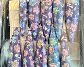 Uñas postizas con flores moradas y azules