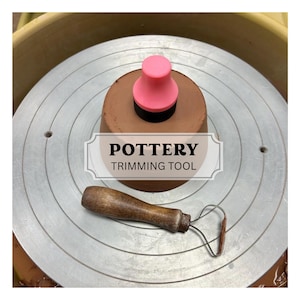 May include: A pottery trimming tool set on a pottery wheel. The set includes a wooden-handled loop tool and a pink and black trimming tool. The text "POTTERY TRIMMING TOOL" is displayed in a white banner.