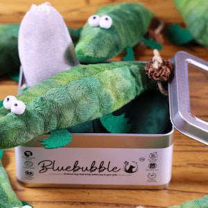 Peut inclure: Un ensemble de jouets en peluche en forme d'alligator vert dans une bo&icirc;te en m&eacute;tal avec le nom de la marque "Bluebubble" imprim&eacute; sur la bo&icirc;te. Les jouets sont con&ccedil;us pour &ecirc;tre des jouets pour chats.