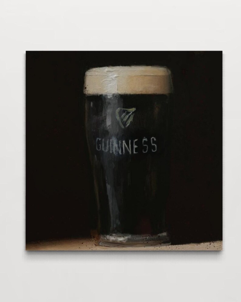 Pu&ograve; includere: Un primo piano di un bicchiere di birra Guinness. Il bicchiere &egrave; pieno di stout scuro e ha una schiuma bianca. Il logo Guinness &egrave; visibile sul lato del bicchiere.