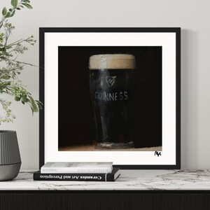 Pu&ograve; includere: Un dipinto in bianco e nero di un bicchiere di birra Guinness. Il bicchiere &egrave; su uno sfondo scuro e il logo Guinness &egrave; visibile sul lato del bicchiere.