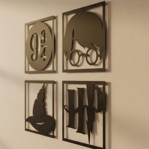 May include: Four black framed wall art pieces featuring iconic imagery. Includes a 9 3/4 sign, a silhouette of a person with glasses, a sorting hat, and the letters HP with a lightning bolt. The art is mounted on a light-colored wall.