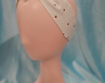 May include: A light blue headband with a white and brown polka dot pattern. The headband is tied in a knot at the top.