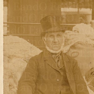 Fantastische kaart voor beroepskasten: Engelse wolhandelaar zit met zijn product 1900