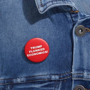 May include: Red button with white text that reads "Trump Flunked Economics!" on a blue denim jacket.