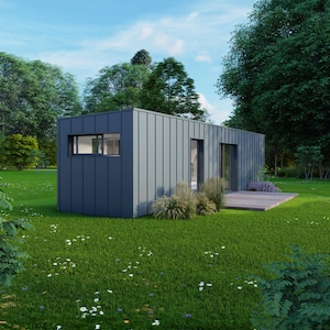 Peut inclure: Une petite maison moderne gris foncé avec un toit plat, une petite fenêtre et une porte coulissante en verre. La maison est entourée d'herbe verte, d'arbres et d'une petite terrasse en bois. L'extérieur est en panneaux verticaux.