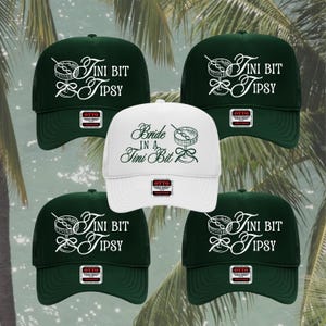 Puede incluir: Cinco gorras de camionero con respaldo de malla. Cuatro son de color verde oscuro con texto blanco "Tini Bit Tipsy" y un gráfico de cóctel. Una gorra blanca dice "Bride in a Tini Bit" en escritura verde con un gráfico de cóctel.