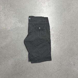 May include: Charcoal gray cargo shorts featuring a structured waistband with belt loops, a small logo patch near the waist, and a prominent flap pocket on the side secured with a metal snap button. The shorts have a clean, straight-leg hemline.