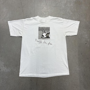 May include: White t-shirt with a small square graphic of a cow lying down, and the text "Really, I'm fine" beneath. The shirt has short sleeves and a crew neck.