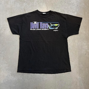Könnte beinhalten: Schwarzes T-Shirt mit dem Text "Devil Rays" in Lila und Weiß sowie einer blau-gelben Rochen-Grafik. Unter dem Teamnamen steht der Schriftzug "Major League Baseball". Das MLB-Logo ist ebenfalls sichtbar.