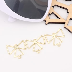 May include: A set of five gold-toned metal triangle pendant charms with a geometric design. Each charm has a loop at the top for attaching to jewelry.