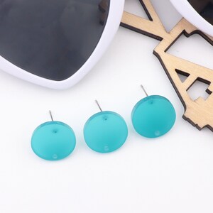 May include: Three turquoise blue round stud earrings with silver posts.
