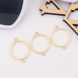 May include: Three gold-colored metal rings with jump rings. The rings are round and have a smooth finish.