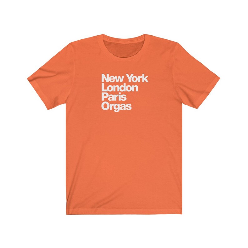 Puede incluir: Camiseta naranja de manga corta con texto blanco que dice "New York London Paris Orgas".