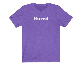 May include: Purple short-sleeved t-shirt with the word "Bored" printed in white on the front.