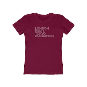 May include: A maroon women's t-shirt with the words "LONDON PARIS TOKYO CHINATOWN" printed in white.