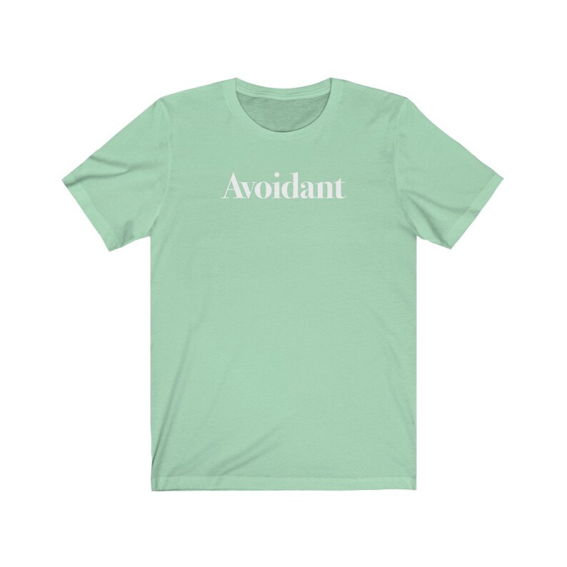 May include: A light green t-shirt with the word "Avoidant" printed in white on the front.