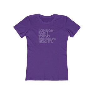 May include: Purple women's t-shirt with the text "LONDON PARIS TOKYO BROOKLYN HEIGHTS" printed in white.