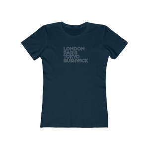 May include: A navy blue women's t-shirt with the words "LONDON PARIS TOKYO BUSHWICK" printed in white on the front.