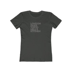 May include: A dark gray t-shirt with the text "LONDON PARIS TOKYO HELL'S KITCHEN" printed in white.