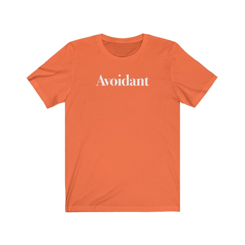 May include: Orange short-sleeved t-shirt with the word "Avoidant" printed in white on the front.