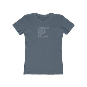 May include: A blue t-shirt with the text "LONDON PARIS TOKYO EAST VILLAGE" printed in white on the front.