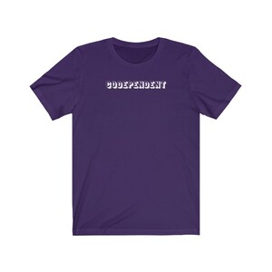 Może przedstawiać: Fioletowy T-shirt z krótkim rękawem z napisem "CODEPENDANT" w kolorze białym.