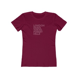 May include: Burgundy women's t-shirt with white text that reads "LONDON PARIS TOKYO FOREST HILLS"