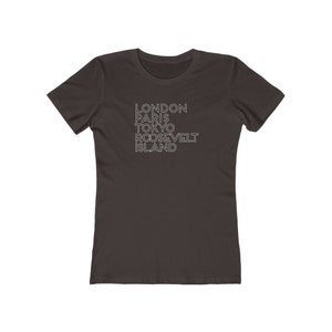 May include: A dark gray t-shirt with the text "LONDON PARIS TOKYO ROOSEVELT ISLAND" printed in white.