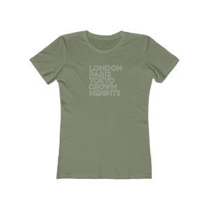 May include: A green t-shirt with the text "LONDON PARIS TOKYO CROWN HEIGHTS" printed in white on the front.