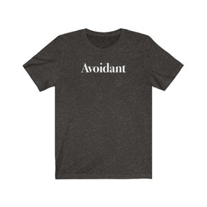 May include: A dark heather grey t-shirt with the word "Avoidant" printed in white on the front.