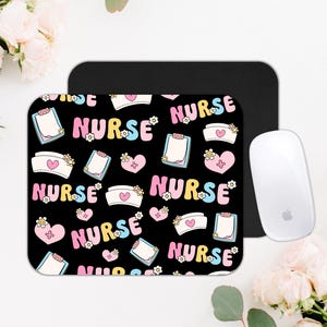 Puede incluir: Una alfombrilla de ratón rectangular con fondo negro que presenta un patrón repetitivo de la palabra NURSE en rosa y azul, cofias de enfermera blancas con corazones rosas, corazones rosas con cruces y portapapeles blancos con papel.
