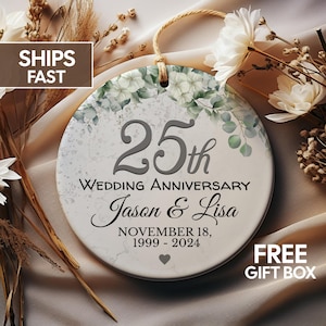 May include: White ceramic ornament with a floral design and the text "25th Wedding Anniversary Jason & Lisa November 18, 1999-2024".