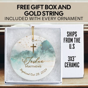 May include: A 3 inch ceramic ornament with a watercolor background in shades of blue and gold. The ornament features a gold cross, the name "Joshua Matthews" and the text "Baptized Oct 28, 2024".