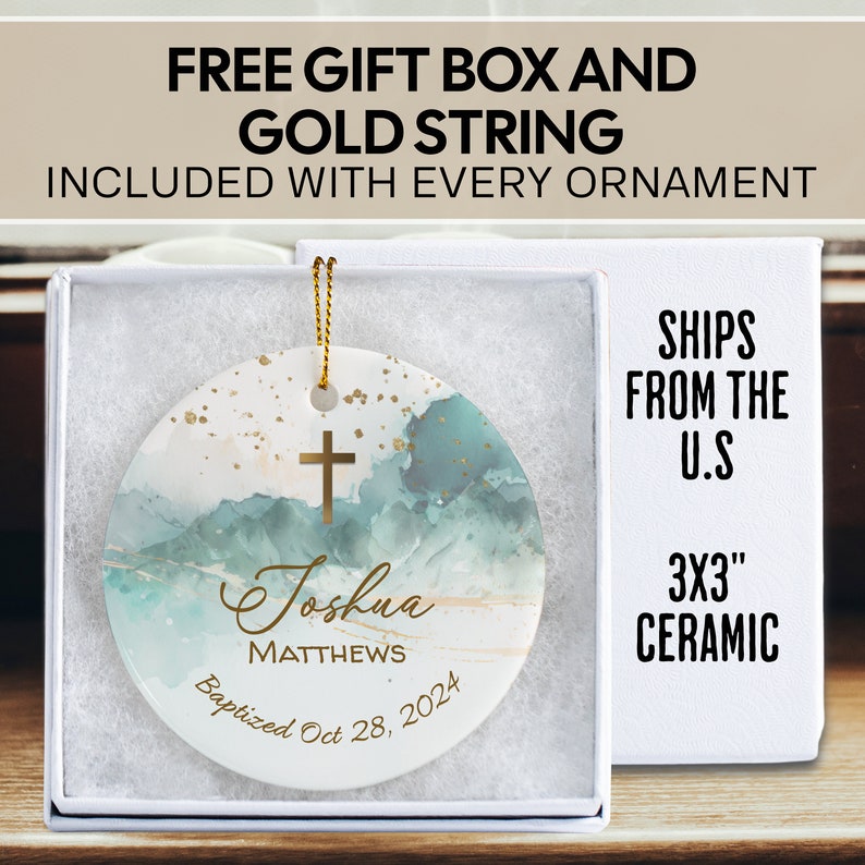 May include: A 3 inch ceramic ornament with a watercolor background in shades of blue and gold. The ornament features a gold cross, the name "Joshua Matthews" and the text "Baptized Oct 28, 2024".