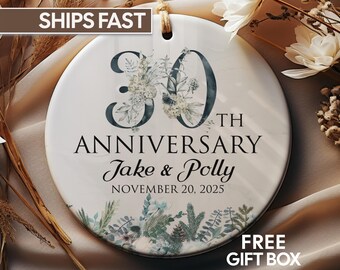 May include: A white ceramic ornament with the text "30th Anniversary" and the names "Jake & Polly" with the date November 20, 2025. The ornament is decorated with floral elements and the words "FREE GIFT BOX".