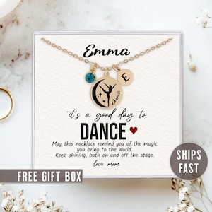 May include: A gold necklace with a charm that says "it's a good day to dance" and a dancer silhouette. The necklace also has a charm with the letter "E" and a blue crystal charm. The necklace is in a white box with the text "Emma" and "love mom".