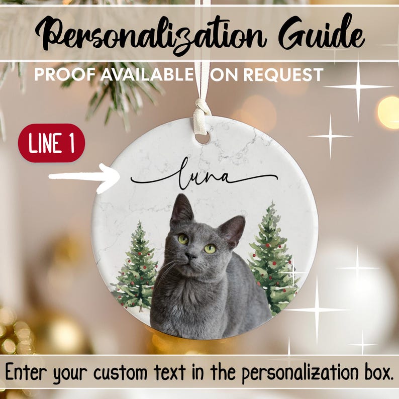 K&ouml;nnte beinhalten: Runder Keramik-Weihnachtsschmuck mit einer Illustration einer grauen Katze und dem Namen "Luna" in Schreibschrift. Der Schmuck hat einen marmorartigen Hintergrund und zwei Weihnachtsb&auml;ume. Der Text oben lautet "Personalization Guide".