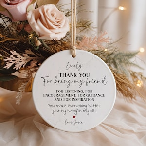 May include: White ceramic ornament with a marble pattern and black text that reads "Emily THANK YOU For being my friend FOR LISTENING, FOR ENCOURAGEMENT, FOR GUIDANCE AND FOR INSPIRATION You make everything better just by being in my life love Josie".