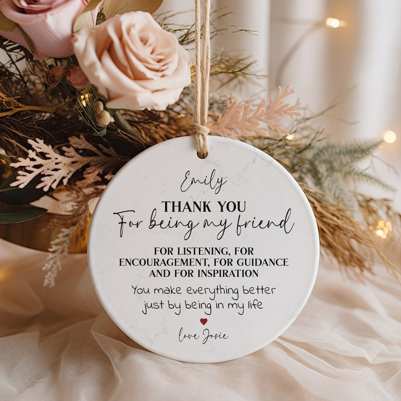 May include: White ceramic ornament with a marble pattern and black text that reads "Emily THANK YOU For being my friend FOR LISTENING, FOR ENCOURAGEMENT, FOR GUIDANCE AND FOR INSPIRATION You make everything better just by being in my life love Josie".