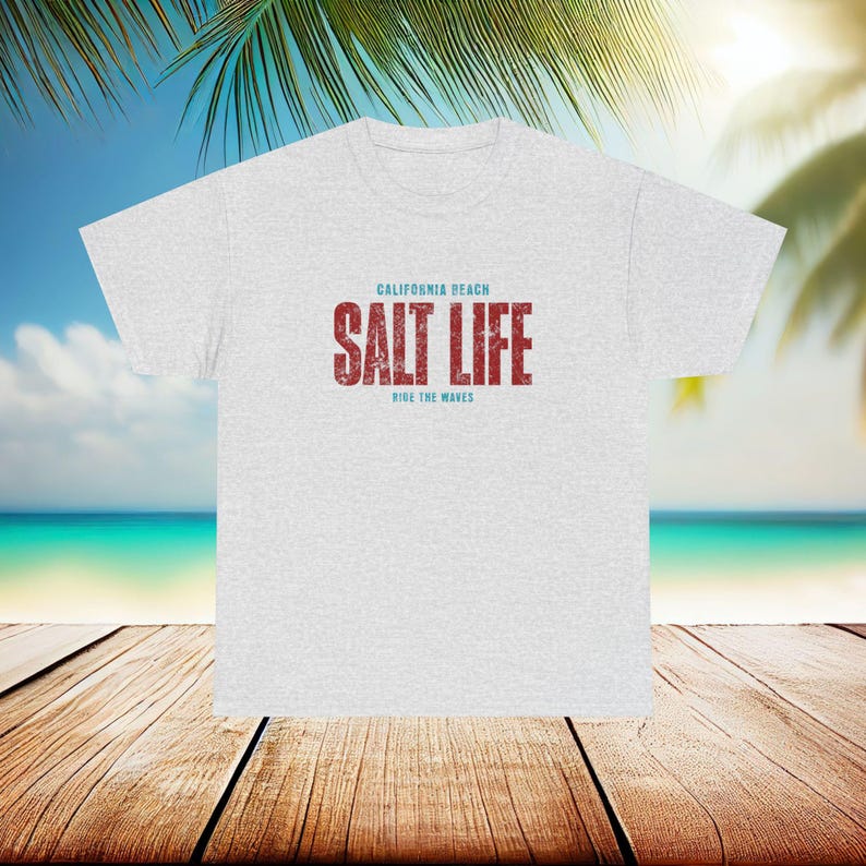 以下が含まれることがあります： グレーのTシャツに「CALIFORNIA BEACH SALT LIFE RIDE THE WAVES」という赤い文字と青い文字で書かれたテキストがあります。