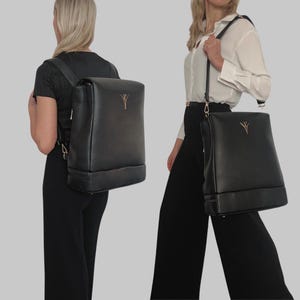 May include: A black rectangular backpack with a fold-over flap and a gold-toned logo emblem on the front. The bag features adjustable straps, allowing it to be worn as a backpack or as a shoulder bag with a single strap configuration.