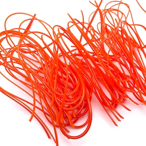 May include: A bundle of bright orange string trimmer line. The line is made of a durable material and is designed to cut through tough weeds and grass.