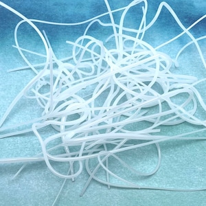 May include: A tangled pile of thin, white, flexible tubes. The tubes are curved and looped, creating a dense, intertwined mass. The background is a gradient of blue and green.