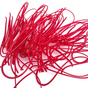 May include: A pile of bright red, flexible, plastic tubing. The tubing is in the shape of a loop, with the ends of the tubing overlapping.
