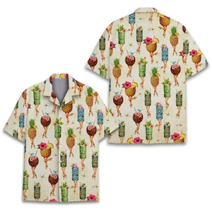 Può includere: Camicia a maniche corte con un motivo ripetuto di cocktail antropomorfi, ananas e maschere tiki. La camicia è beige con un tema tropicale, con colori vivaci e un design giocoso. La camicia è visibile dalla parte anteriore e posteriore.