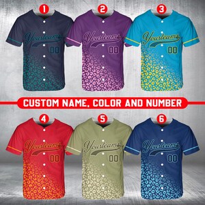 Puede incluir: Seis camisetas de béisbol con un diseño de estampado de leopardo. Las camisetas son de diferentes colores, incluyendo morado, azul, rojo, verde y amarillo. Las camisetas tienen el texto "Yourteams" y el número "00" en la parte delantera.