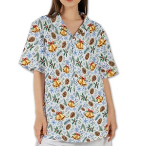 May include: A short-sleeved button-down shirt featuring a white background with a repeating holiday pattern of gold bells with red bows, brown pinecones, green pine needles, holly leaves, and small blue berries across the entire garment.