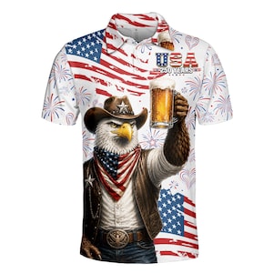 Peut inclure: Polo blanc avec un motif patriotique. Il pr&eacute;sente un aigle portant un chapeau de cowboy tenant une bi&egrave;re et un drapeau am&eacute;ricain. Le t-shirt comprend le texte "USA 250 YEARS" et des feux d'artifice.